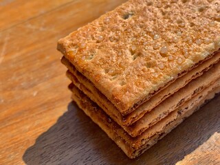 

Stacks of the crunchy crisp bread biscuits with granulated sugar on the wood table with closeup shot and natural lighting