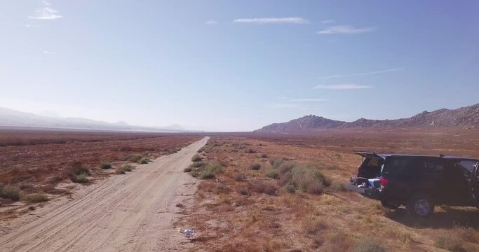 Backwards Drone Footage Of Dusty Road In the Desert In California.