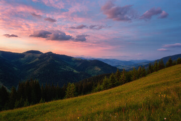 Naklejka na ściany i meble Amazing sunset mountain landscape. Scenic view of the summer alpine meadow, mountain range and colored sky with clouds, natural outdoor travel background, Carpathian Biosphere Reserve