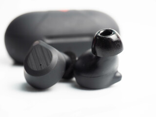 A pair of black wireless earphone with case