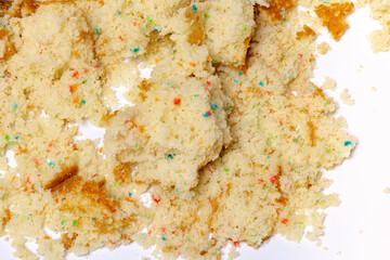 Crumbled confetti birthday cake spread on a white background.