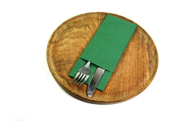 knife and fork at napkin on old rustic wooden board isolated on white background