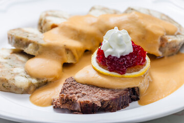 sirloin sauce with dumplings and cranberries on lemon with whipped cream