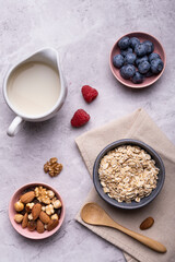 Concept of healthy nutrition. Food for breakfast, top view, a bowl with whole and organic oat cereals, dried fruit, fresh fruit and oat drink.