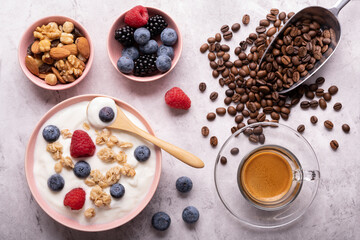 Concept of healthy nutrition. Food for breakfast, top view, a bowl with low-fat yogurt, crunchy oatmeal, dried fruit, fresh fruit and espresso.