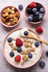 Concept of healthy nutrition. Food for breakfast, top view, a bowl with low-fat yogurt, crunchy oatmeal, dried and fresh fruit.