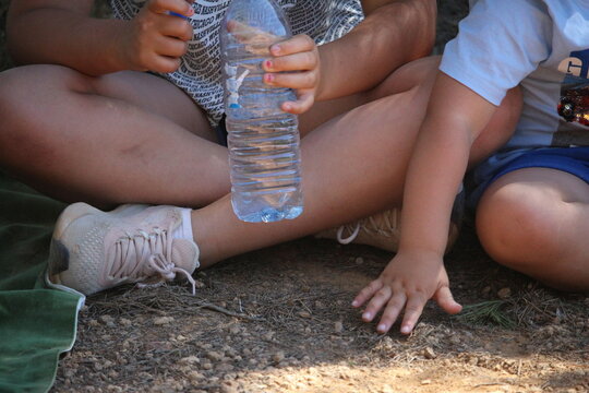 enfants assis dehors buvant de l'eau