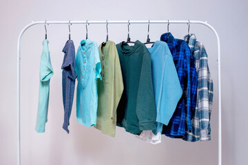 Rack with stylish children's clothes on hangers for a preschool boy. Wardrobe for a little boy