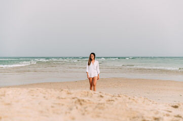 Fototapeta na wymiar Happy woman standing on sandy beach