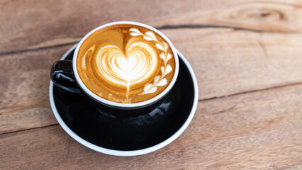 Hot art coffee cappuccino in a cup on wooden table background  with copy space