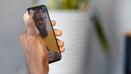 Young man communicating by videoconference using smartphone