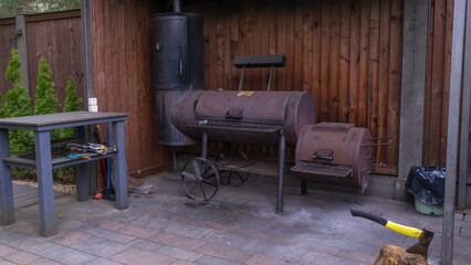 Vintage drum barrel charcoal BBQ in garden. Old barbeque outside in garden. Retro flaming coals...