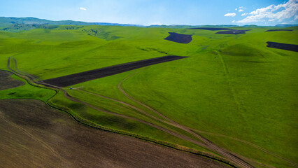 Obraz premium Top view from a drone on mountain pastures and road