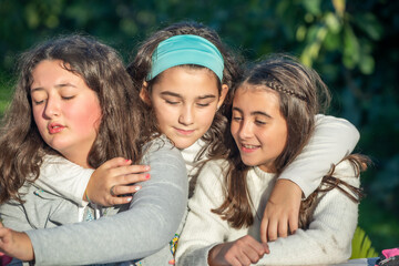 Three happy young girls playing outdoor together.