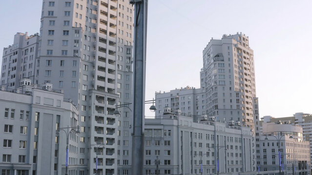 Luxurious new apartament house with a white facade. Stock footage. Summer city street and the complex of buildings, modern district of a big city on blue sky background.