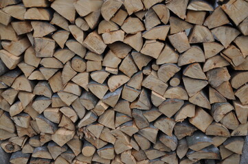 A stack of wood prepared for the cold winter. Croatia countryside. Firewood stacked fire wood different sizes.Dry chopped firewood stacked up in a pile.