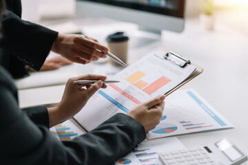 Close up. two business people pointing graph talking, planning analyze investment and marketing in office. Business meeting to brainstorm the new project and analysis data document.