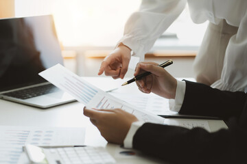 Close up. two business people pointing graph talking, planning analyze investment and marketing in office. Business meeting to brainstorm the new project and analysis data document.