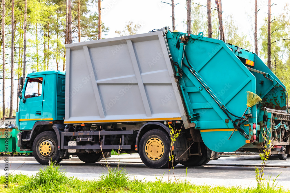 Aufkleber A garbage truck picks up garbage in a residential area. Loading mussar in containers into the car. Separate collection and disposal of garbage. Garbage collection vehicle.