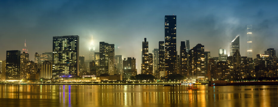 Manhattan skyline at night with reflections, NYC, USA.
