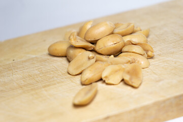 Fototapeta na wymiar Salted peanuts peeled separately on a wooden table.