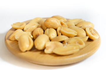 Salted peanuts peeled separately on a wooden table.