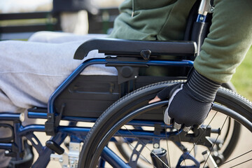 Obraz premium Close Up Of Teenage Boy Wearing Protective Gloves In Wheelchair In Park