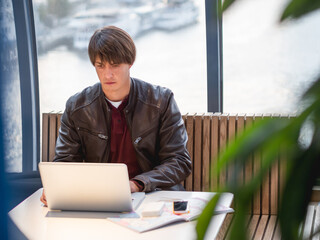 Businessman works with laptop and paper organiser in co-working center. Workplace for freelancers...