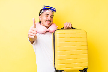 young hispanic man feeling proud,smiling positively with thumbs up. travel concept