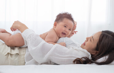 Loving mom carying of her newborn baby at home. Bright portrait of happy mum holding sleeping...
