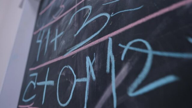 Live Camera Moves Along Blackboard With Numbers Written With Chalk. Close-up Educational Chalkboard In Kindergarten School Indoors With No People