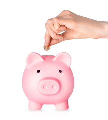 Human hand putting coins in piggy bank isolated on white background. Money saving concept