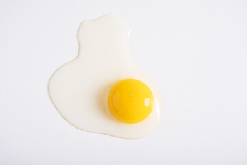 Broken fresh quail egg on a white background.