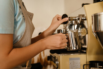 Fototapeta na wymiar Young asian barista woman making coffee in cafe