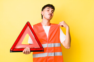 young hispanic man looking arrogant, successful, positive and proud. emergency car triangle