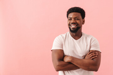 Black mid man smiling while posing with arms crossed
