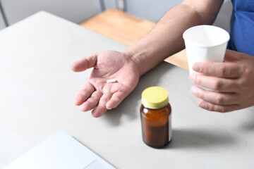 薬を飲む高齢者の手元