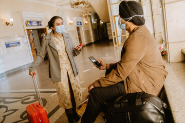 Indian couple talking and using mobile phones in airport