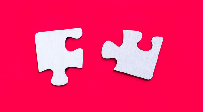 On a bright red background are two white empty puzzles. View from above. Copy space