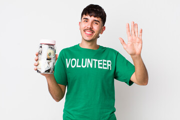 hispanic volunteer smiling happily, waving hand, welcoming and greeting you. donations concept