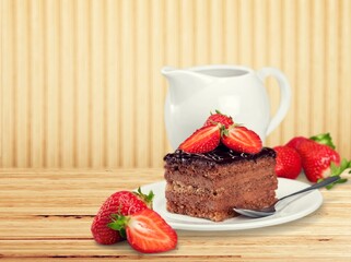 Tasty homemade chocolate cake on the plate on the desk