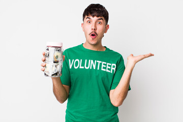 hispanic volunteer looking surprised and shocked, with jaw dropped holding an object. donations...