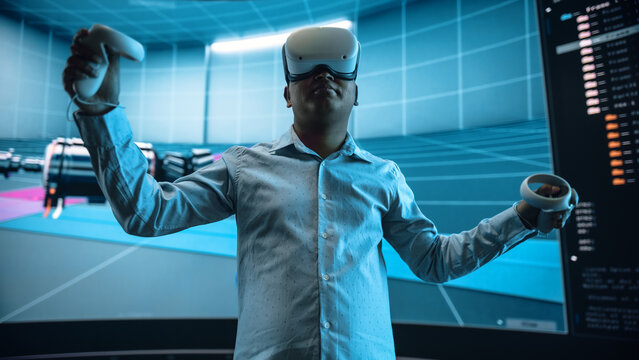 Automotive Engineer Making Presentation of a Modern VR Software Testing and Developing Vehicle Platforms. Engineer Uses Headset and Controllers to Showcase Functionality on a Big Screen on Stage.
