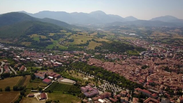 Panning shot by drone of Fabriano city with beautiful mountains behind. Italy, Marches