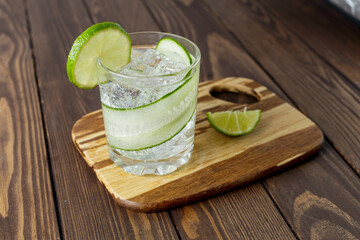 cucumber cocktail with lime and ice is on the table.