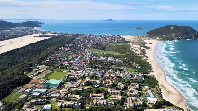 Aerial drone scene of urbanized paradise beach with sand strip dunes mountains and sea santinho beach Florian&oacute;polis