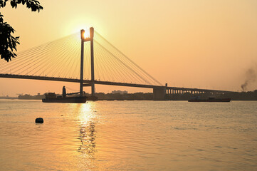 Obraz premium Beautiful famous Kolkata Hoogly bridge in sunset . light reflection on Ganges top sights. Travel tourism in Kolkata.