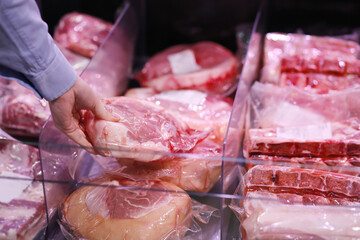 man purchasing a packet of meat at the supermarket.