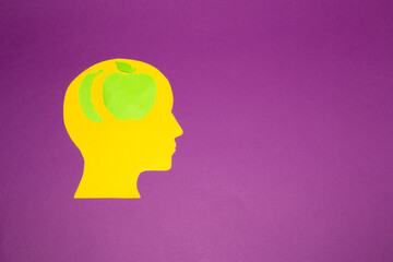 yellow paper head with apple and banana brain on purple background, creative art design, healthy and fresh food, vitamin diet, copy space, summer vibe
