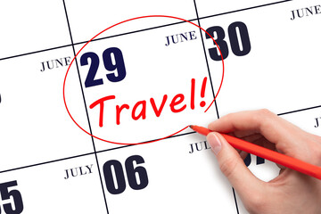 29th day of June. Hand drawing a red circle and writing the text TRAVEL on the calendar date 29...